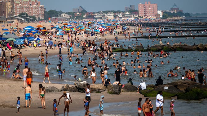 NEW YORK, NEW YORK - JULY 30: People try to stay cool at the beach at Coney Island in Brooklyn as the region experiences another heatwave on July 30, 2025 in New York City.