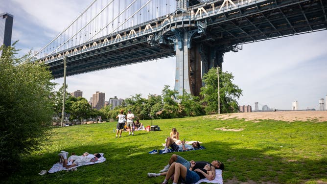NEW YORK, NEW YORK - JUNE 04: People enjoy a warm afternoon in the Dumbo neighborhood of Brooklyn on June 04, 2026 in New York City. Temperatures are expected to reach the mid 90's in New York on Friday and Saturday as the city gears up for the summer season.