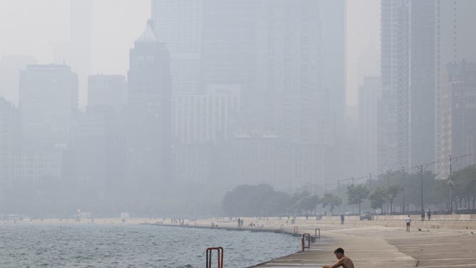 CHICAGO, ILLINOIS - JULY 16: People cool off along Lake Michigan as smoke from Canadian wildfires blankets the city on July 16, 2026 in Chicago, Illinois. City officials have encouraged people to stay inside as the air quality index today in the city has been rated "very unhealthy", with some nearby suburban areas rated "hazardous".