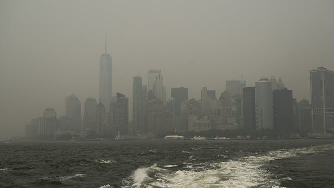 NEW YORK, NEW YORK - JULY 16: Haze from Canadian wildfires blankets the Manhattan skyline as seen from a Staten Island Ferry on July 16, 2026 in New York City. Much of the East Coast and Canada is under an Air Quality Health Advisory as the Canadian and Great Lakes wildfire smoke gradually moves through the area, creating a thick haze in the heat. The region is experiencing temperatures with heat indexes over 100 degrees as it confronts another heat wave.Ahead Of World Cup Final, NYC Metro Area Under Smoky Skies Due To Canadian Wildfires.
