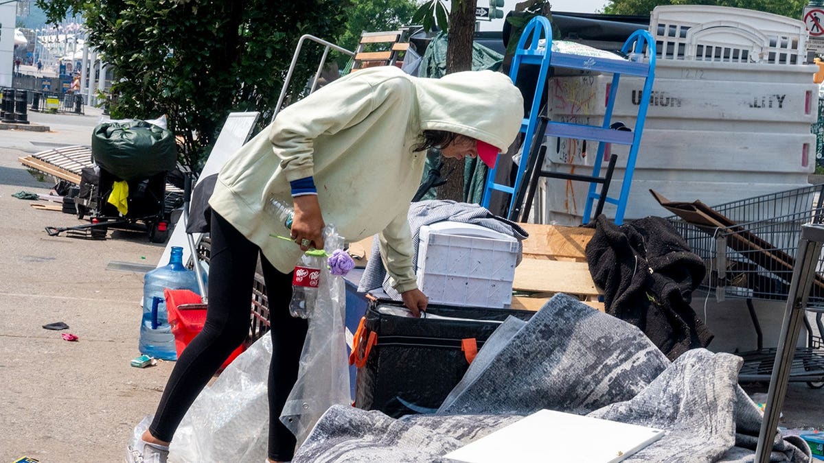 A woman walking around the homeless encampment