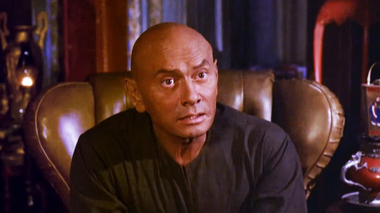 Yul Brynner's Carson leans forward in a chair in The Ultimate Warrior