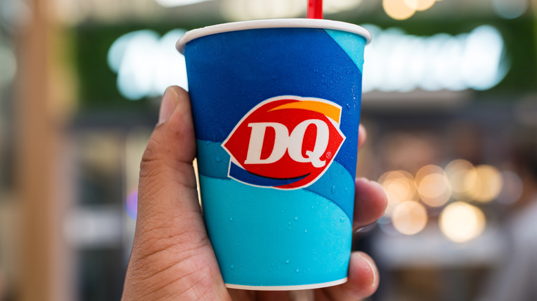 Hand holding Dairy Queen Blizzard cup with straw
