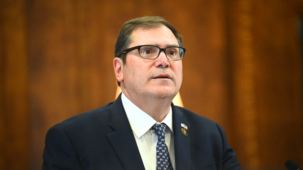 John Sarcone, the US attorney for the Northern District of New York looks on.