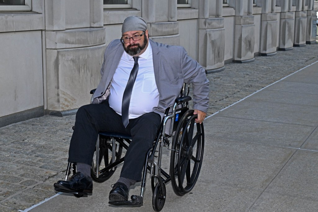 John Merrone in a wheelchair outside Brooklyn Federal Court.