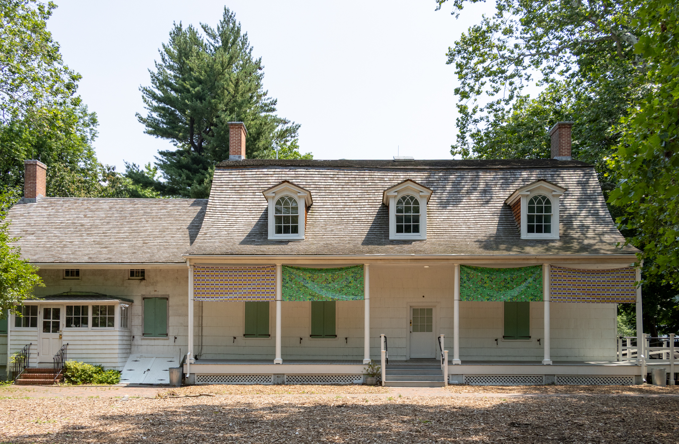 the exterior of the lefferts house with dormers and banners hanging from the columns
