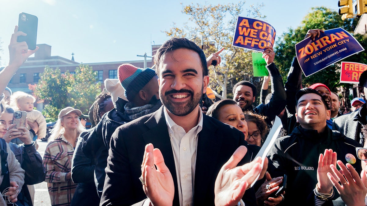 Zohran Mamdani, New York City mayoral candidate, campaigns in the Brooklyn borough of New York with a crowd around him.