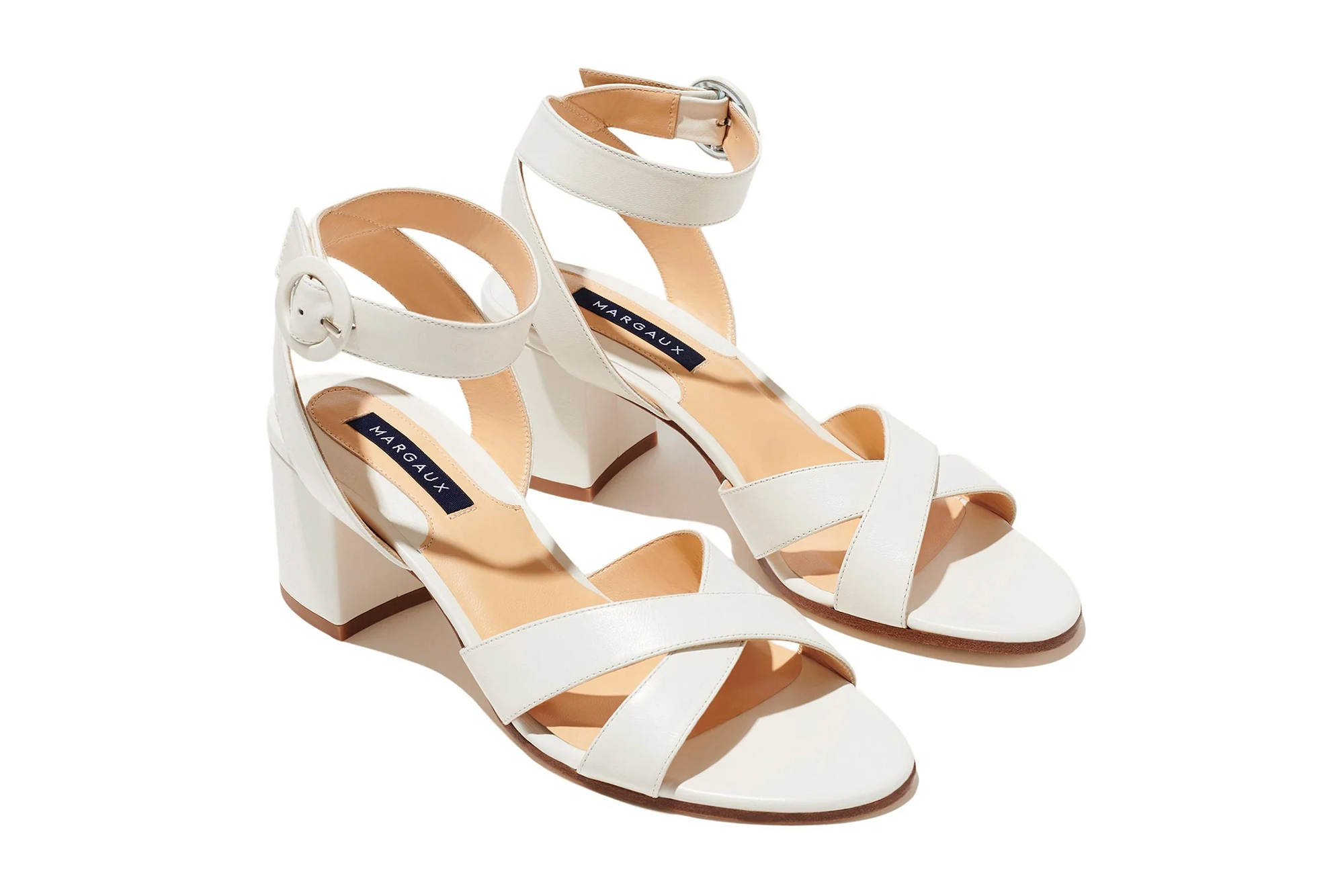 Pair of ivory Margaux The City Sandal with block heels and ankle straps.