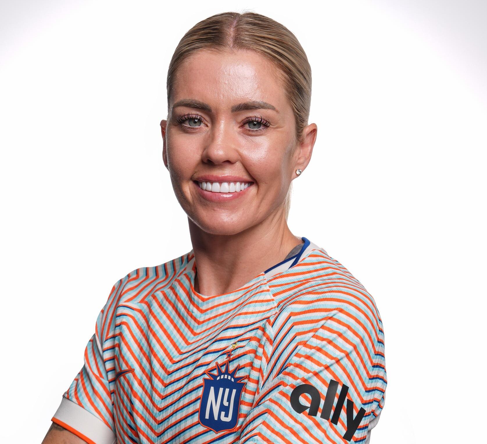 A player smiles and poses for a photo in a multicolored NJ/NY Gotham FC jersey