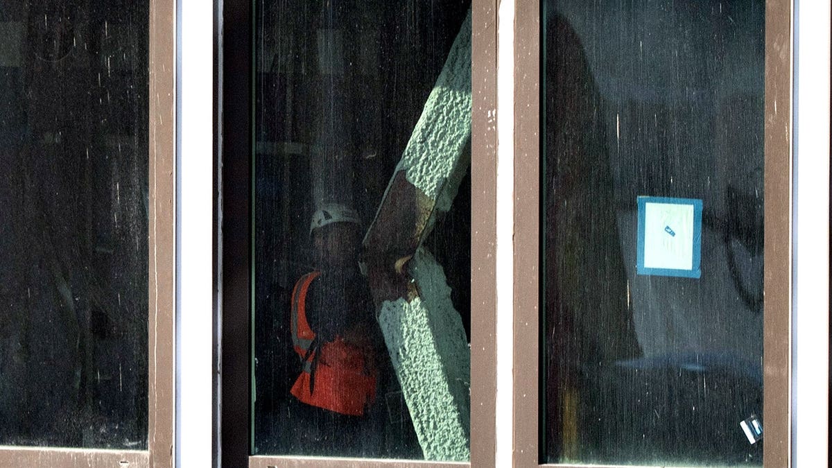 construction worker inspects buckled support beam