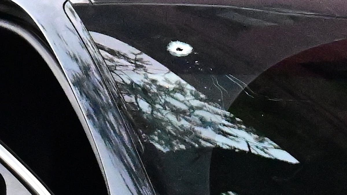 a bullet hole in the front windshield on the passenger side of an unmarked NYPD vehicle
