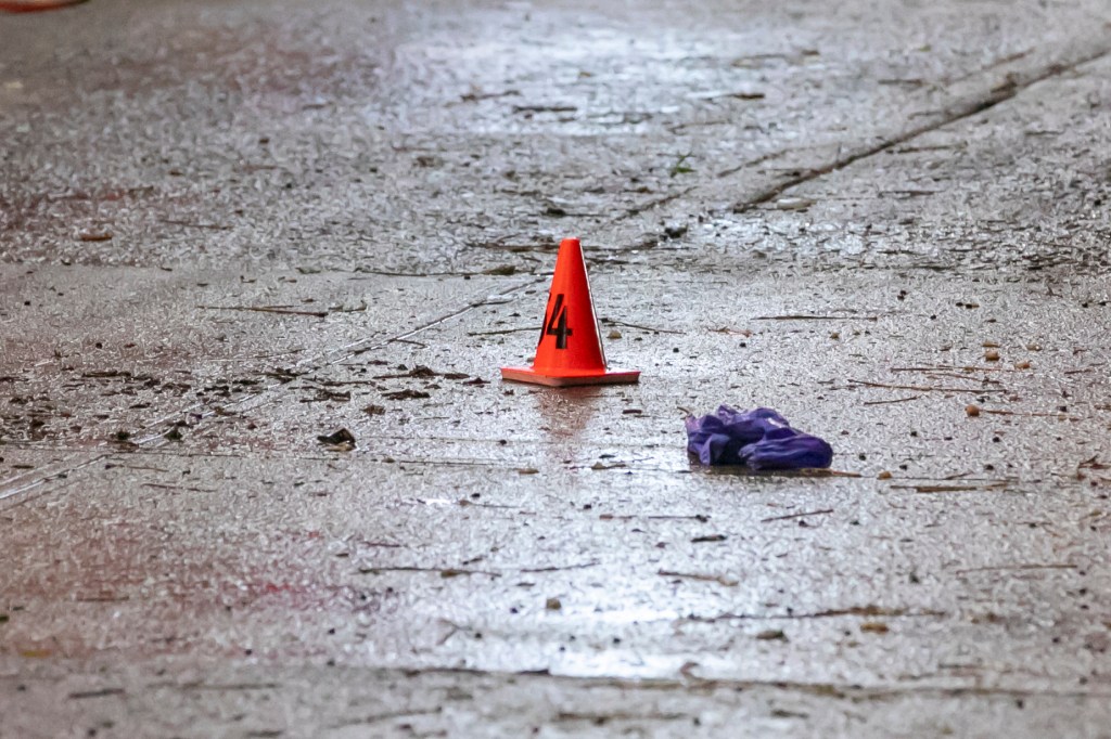 Crime scene marker 14 and a purple glove on a wet sidewalk.