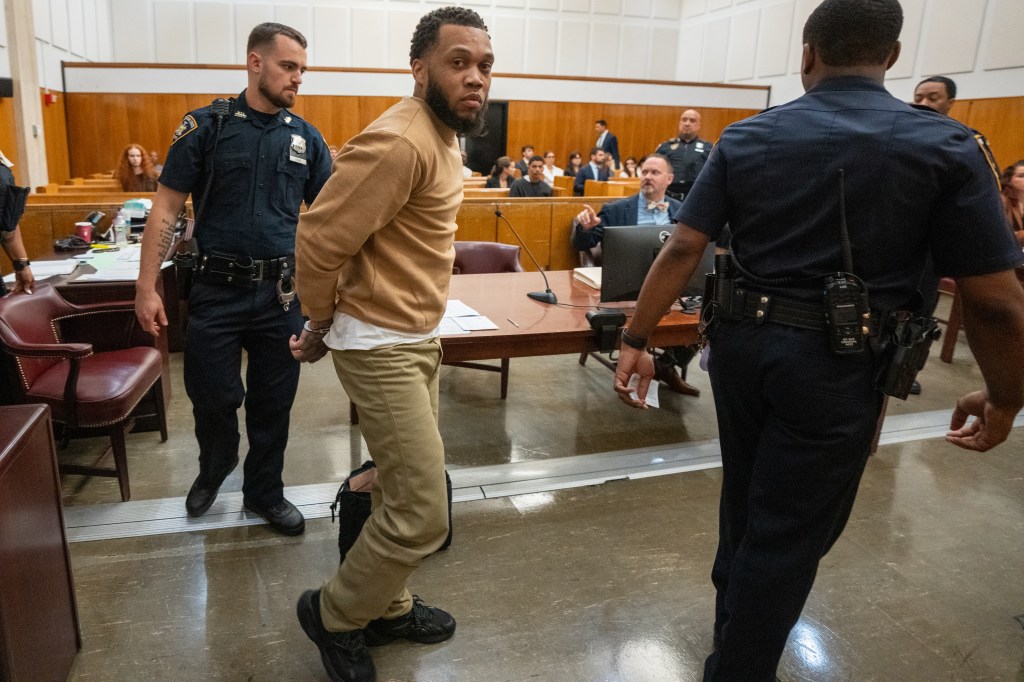 Donovan Murphy, handcuffed, being escorted by two officers in a courtroom.