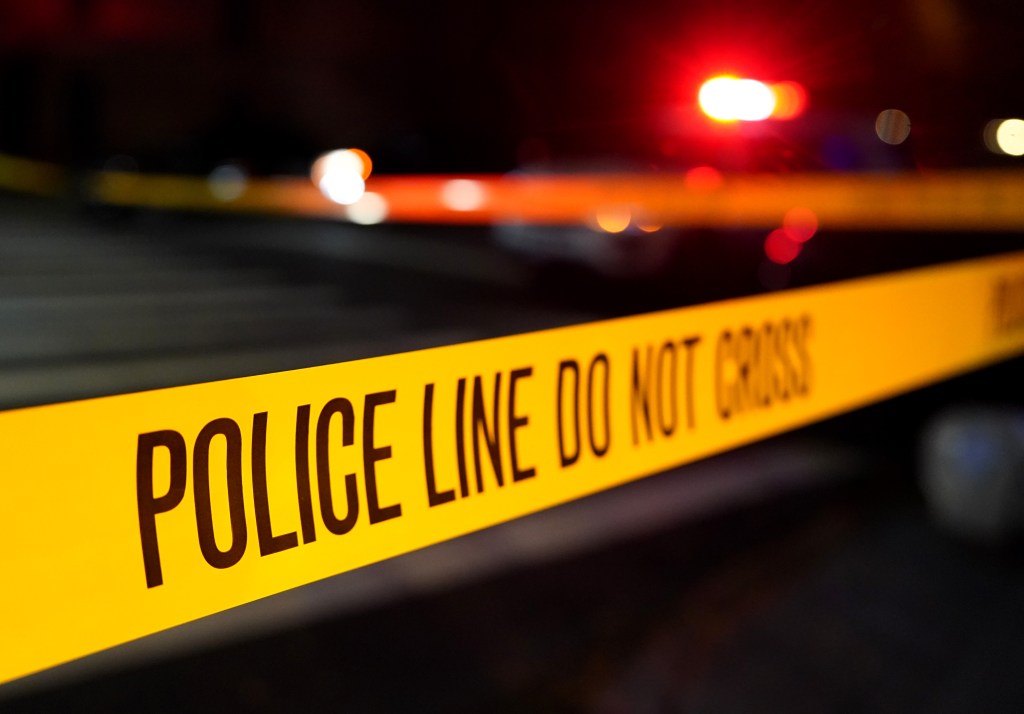 Police Line Do Not Cross tape at a crime scene at night.