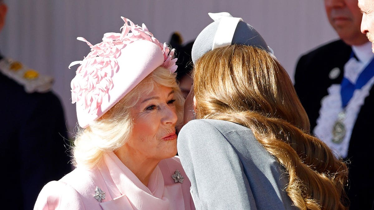 Queen Camilla kissing Catherine Princess of Wales at a formal welcome in Windsor England