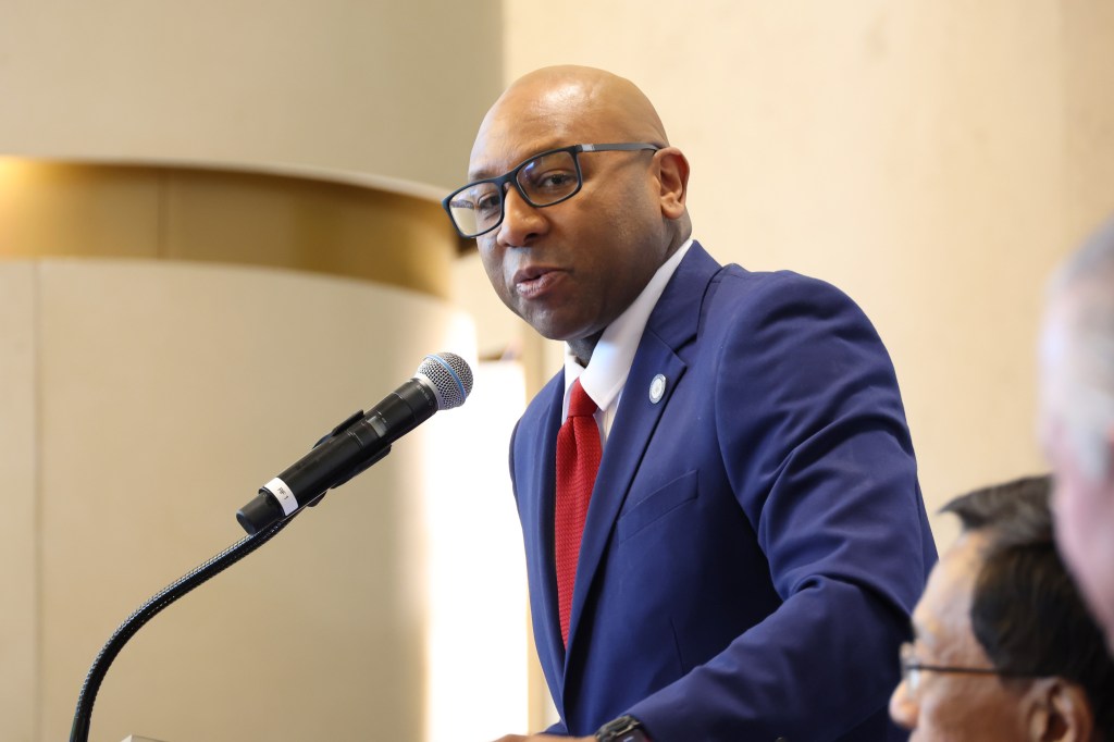 Queens Borough President Donovan Richards Jr. speaking at a microphone.