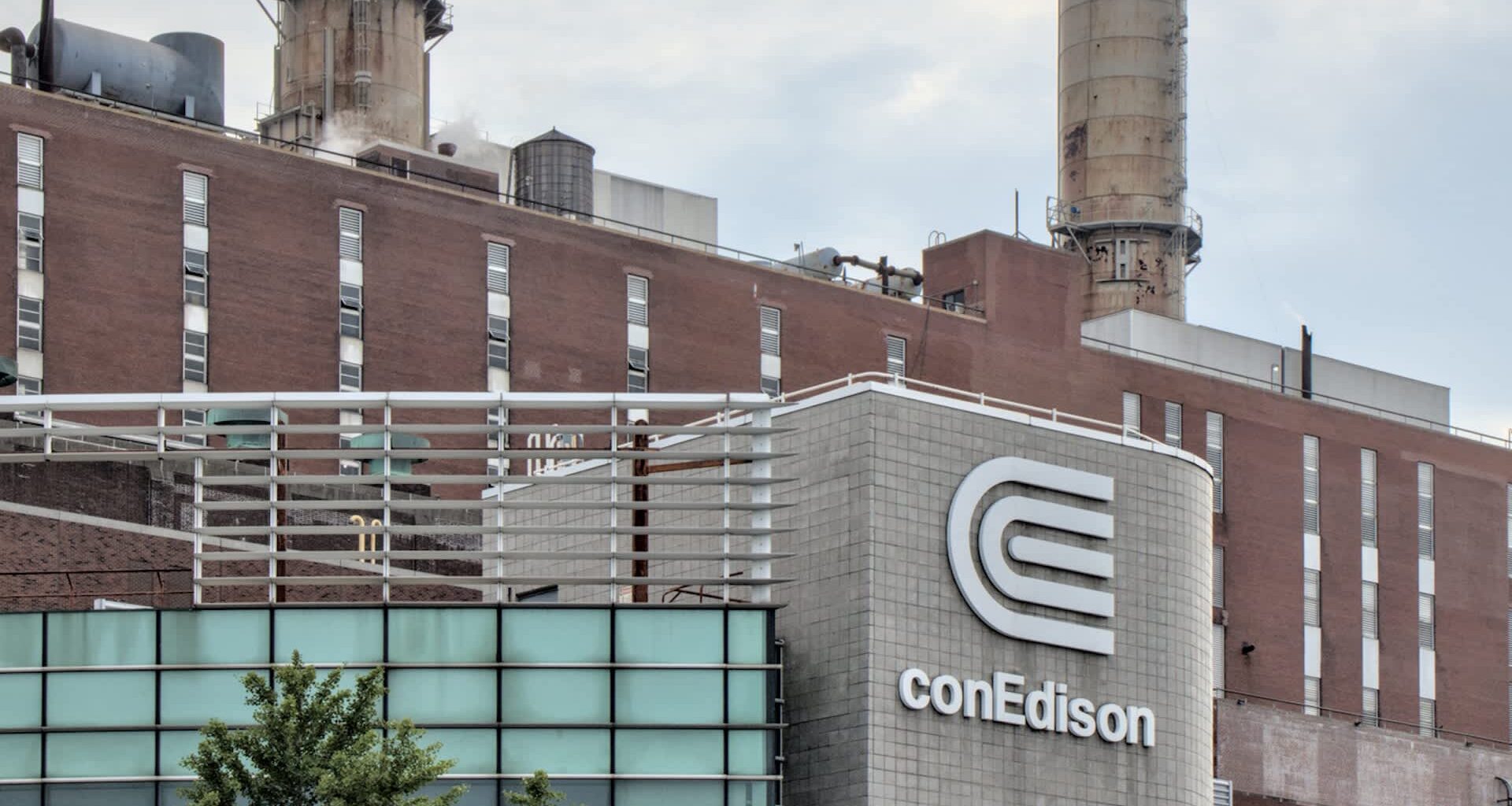 The conEdison building features a prominent logo, with industrial structures and smokestacks in the background.