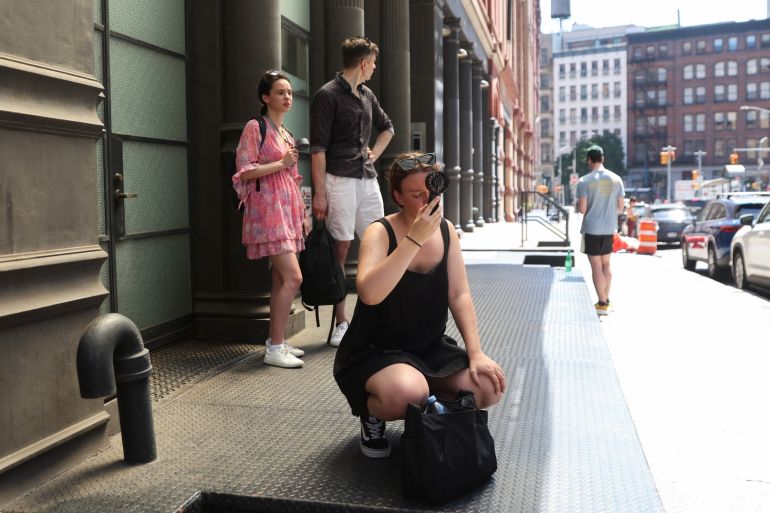 Women use fans to cool off themselves outside singer Taylor Swift's residence in Manhattan amid reported wedding celebrations for her and National Football League (NFL) player Travis Kelce, during a heatwave in New York, U.S., July 3, 2026. REUTERS/Heather Khalifa
