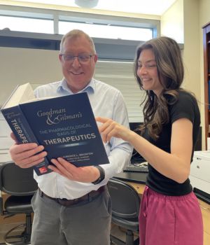Shannen McDermott and Dean Burkin M.D., studying a textbook.