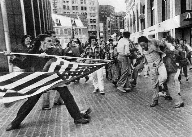 Stanley Forman's photo titled 'The Soiling of Old Glory,' shows an attack on a young black lawyer, Ted Landsmark, in downtown Boston during a 1976 anti-busing demonstration. (Herald file photo)
