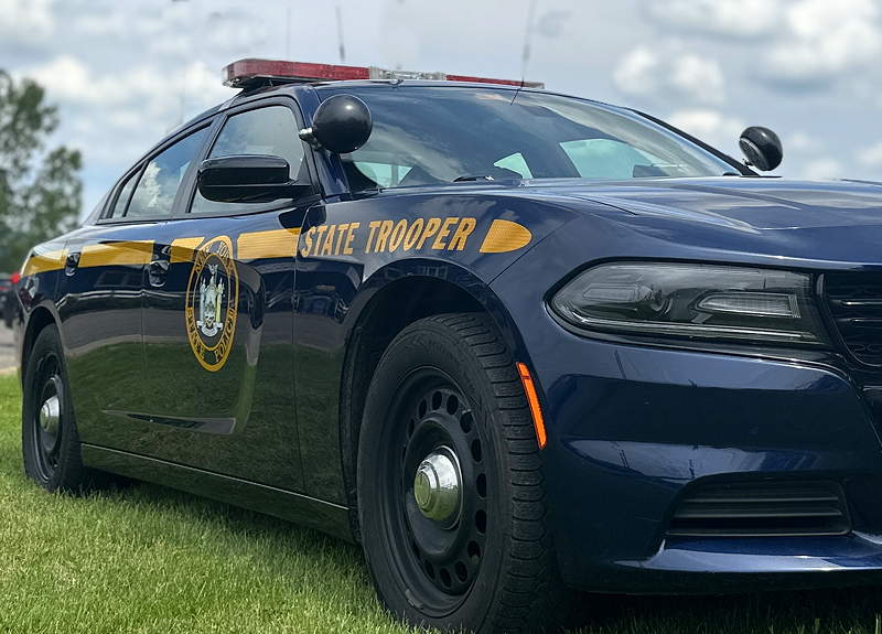 The side of a New York State Police car sitting on lawn