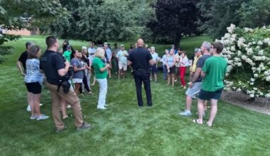 police officer talks to a group of residents