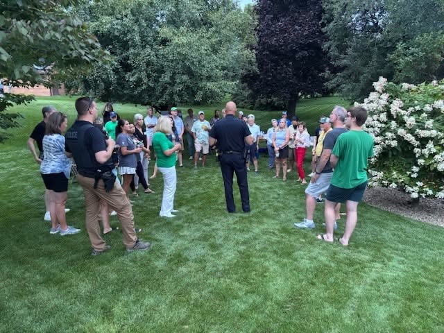 police officer talks to a group of residents