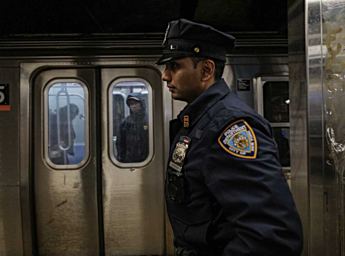 cop on a platform after subway shooting in Brooklyn