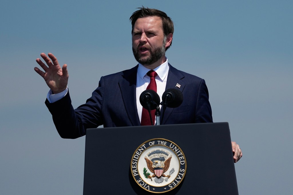 JD Vance speaks at a podium with the Vice President's seal.