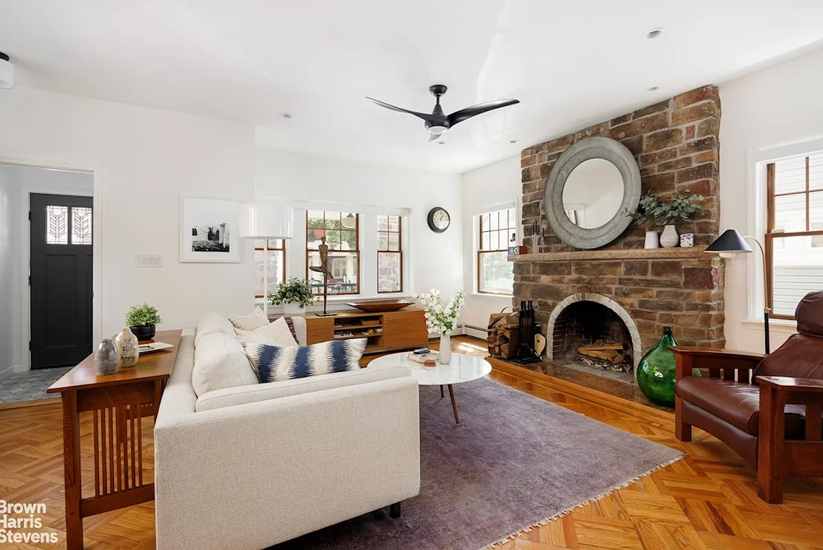 living room with stone fireplace, wood floor