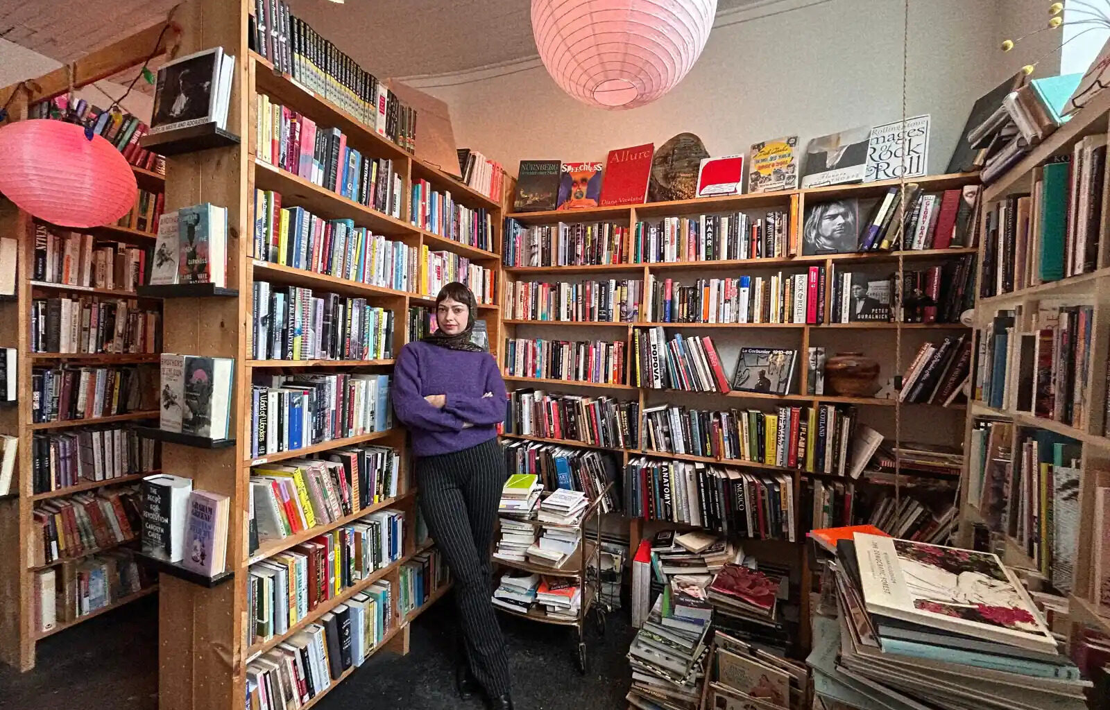 bookshelves with book store owner in foreground