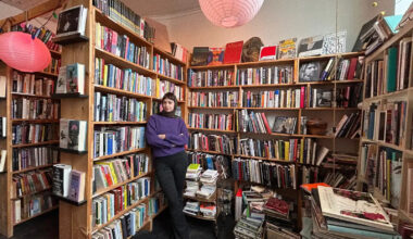 bookshelves with book store owner in foreground