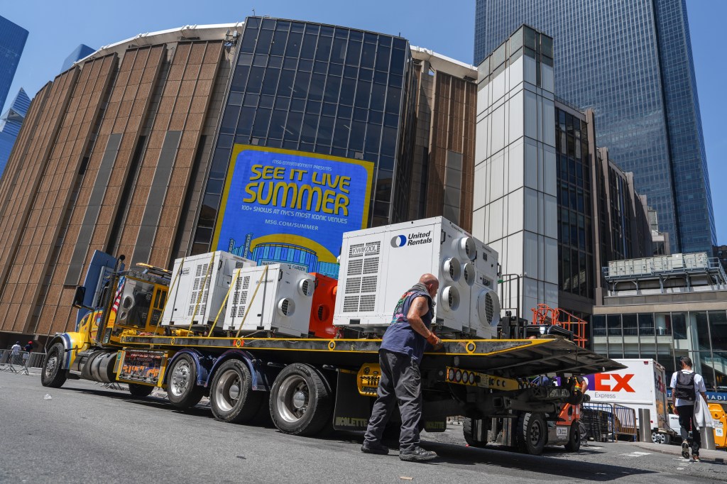 A worker unloads portable air-conditioning units from a truck outside Madison Square Garden.