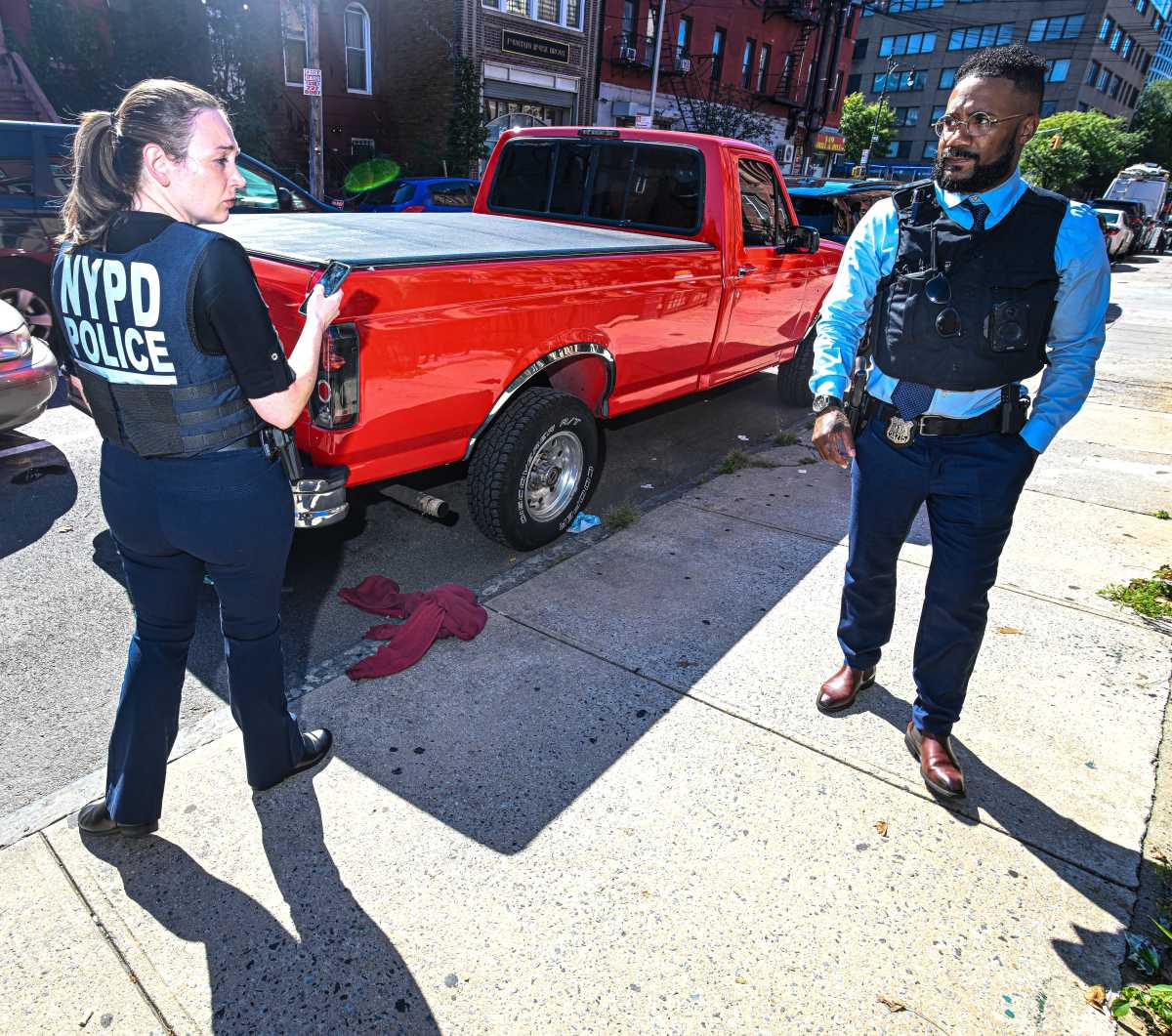 cops stnading near pickup truck where they found evidence from bronx bodega shooting