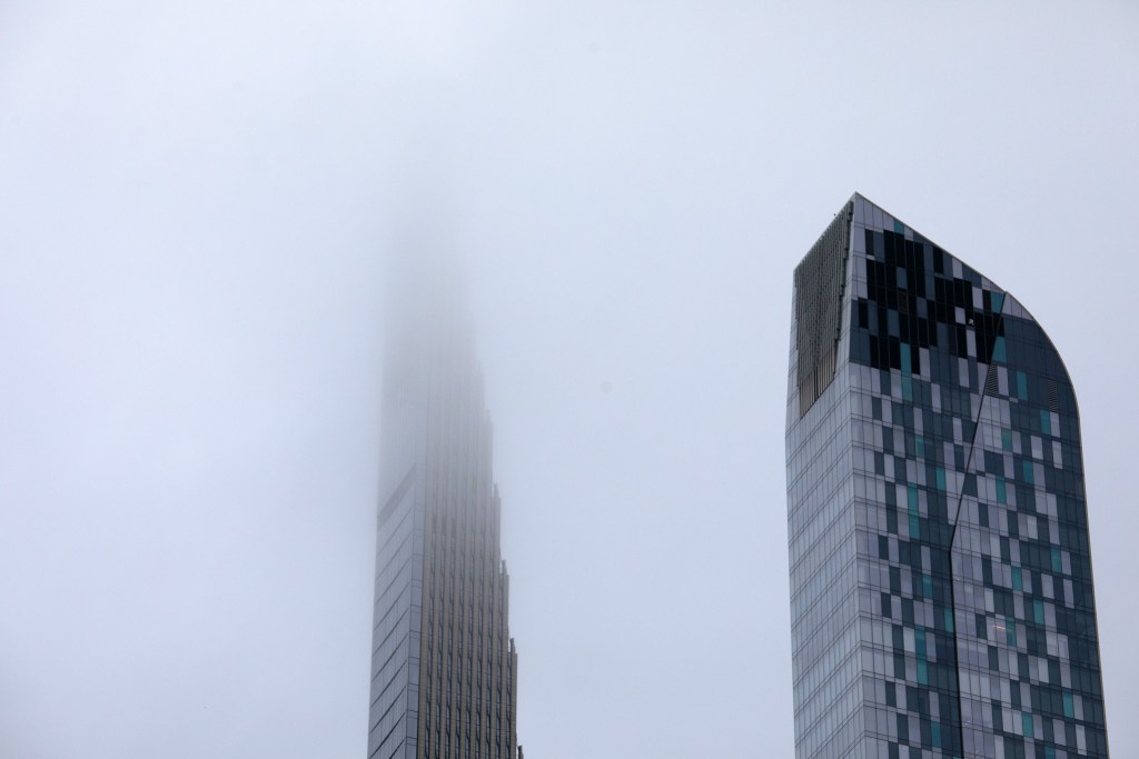 Fog envelopes the tops of residential buildings along Billionaires’ Row