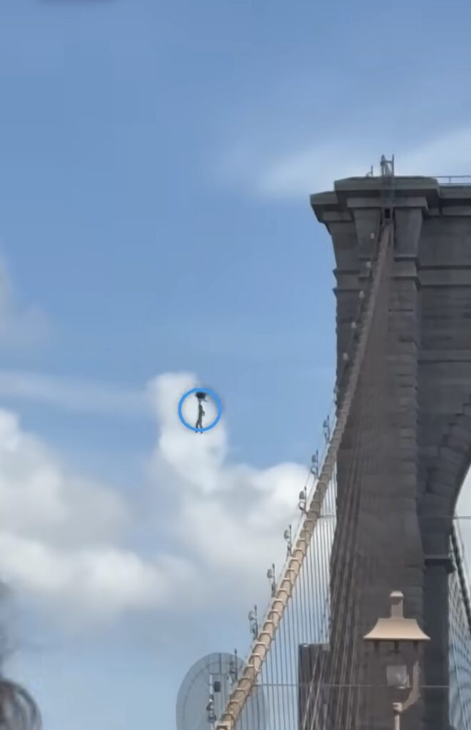 Guy Climbs Brooklyn Bridge, Waves Flags, Strips, and Jumps
