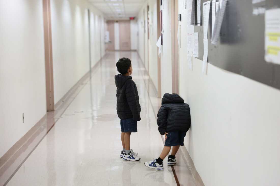 Children wait outside of an immigration court at the Jacob K. Javits Federal Building on July 31, 2026 in New York City. More than 1,400 migrant children across New York, including more than 700 in New York City, are set to lose legal representation as a $200 million federal contract with the Acacia Center for Justice expires. The nonprofit oversees legal services for unaccompanied migrant children and estimates the funding loss will affect more than 24,000 children nationwide. (Photo by Michael M. Santiago/Getty Images)