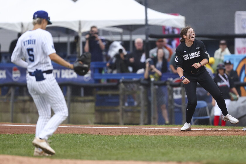 Maggie Foxx of the Los Angeles Queens reacts after hitting an RBI single as London Studer of the New York Heights looks on during the first inning Saturday in Springfield.