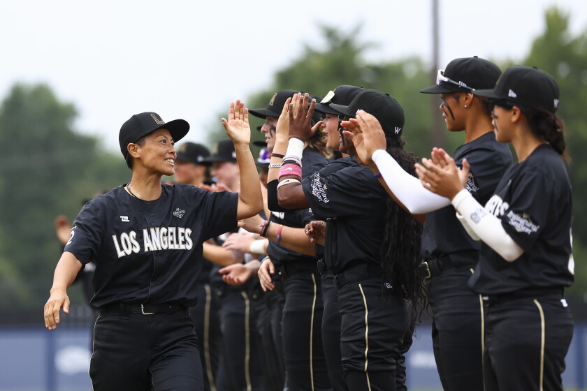 Ayami Sato of the Los Angeles Queens high fives teammates before the Women's Pro Baseball League Opening Day Saturday in Springfield.
