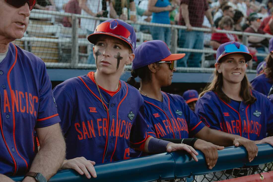 From left to right: Coach Matt Williams, second baseman Amanda Gianelloni, catcher Samantha Gutierrez, and left fielder Skylar Kaplan of the San Francisco Firebells in the dugout at Robin Roberts Stadium prior to their first game in the Women's Pro Baseball League. Springfield, IL, August 2, 2026.