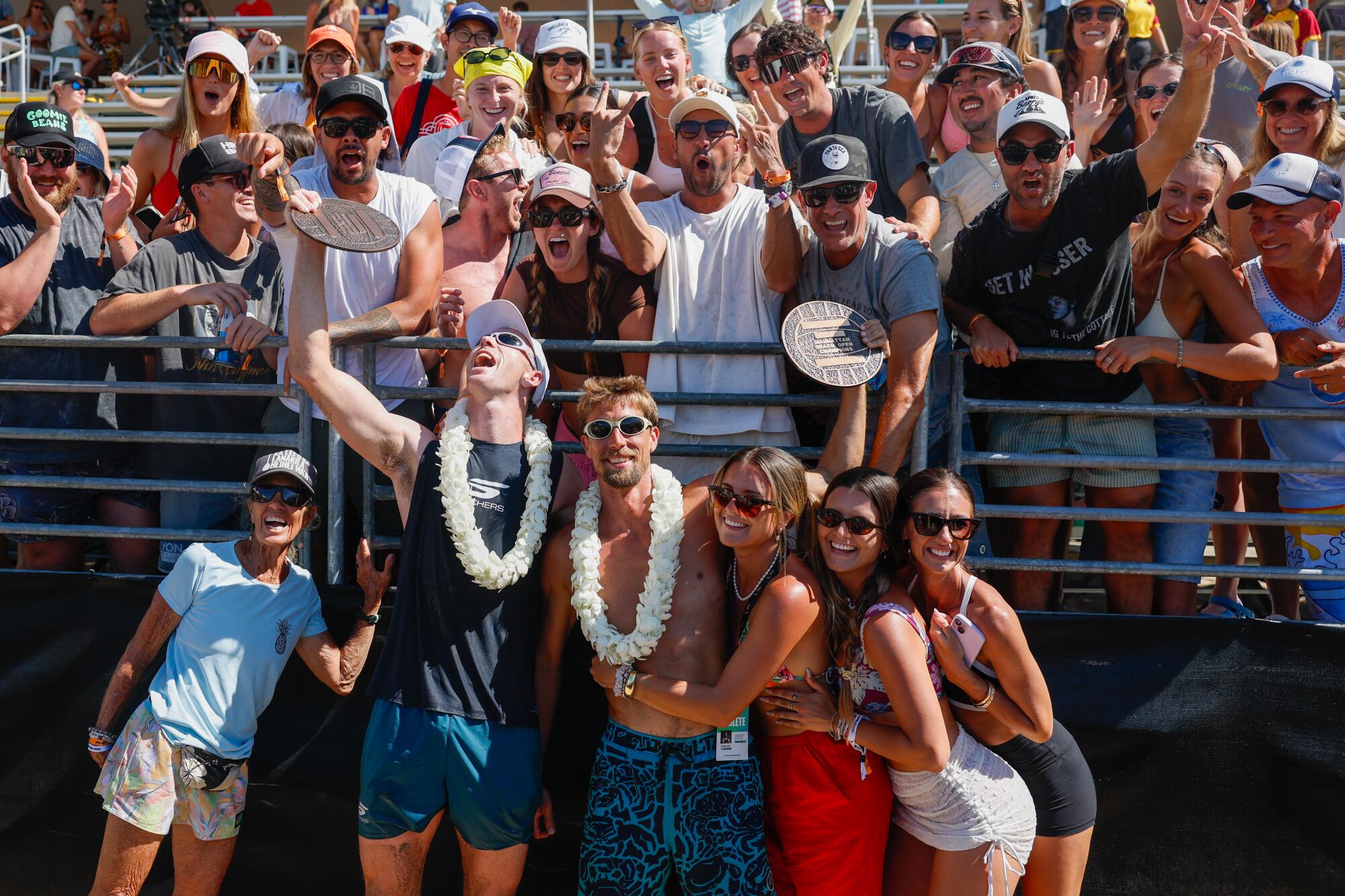 Andy Benesh and Taylor Crabb stand alongside friends and family after winning the AVP Manhattan Beach Open on Sunday.