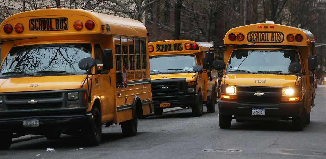 In this photo, three yellow school buses idle in a street in Manhattan's East Village on January 15, 2013.
