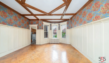 dining room with wainscoting, coffered ceiling, wallpaper
