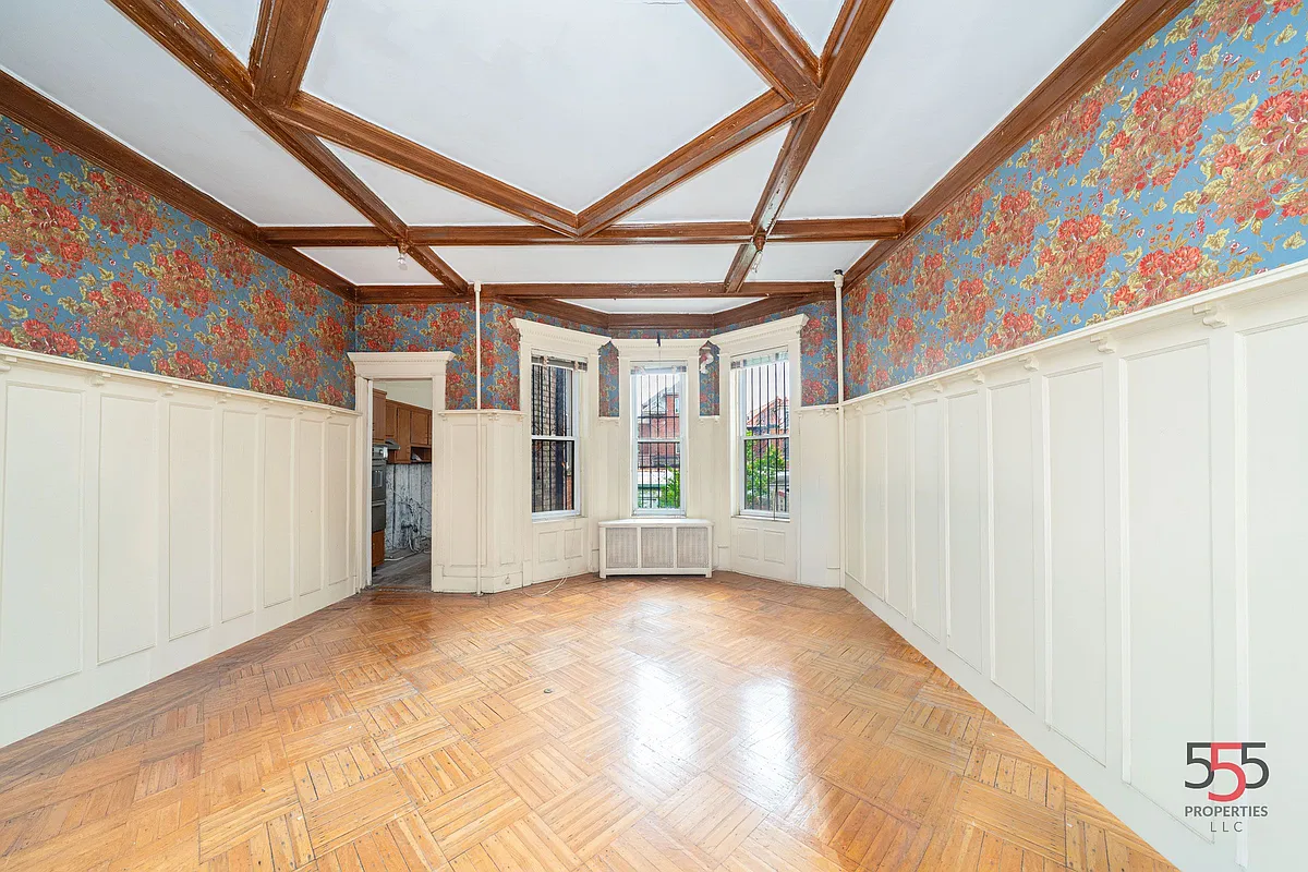 dining room with wainscoting, coffered ceiling, wallpaper
