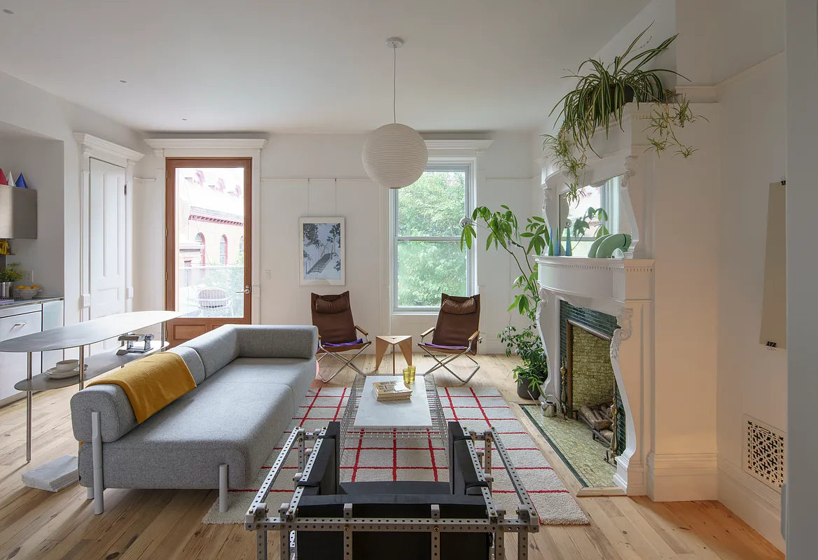 bed stuy open plan living and kitchen with a mantel and white walls