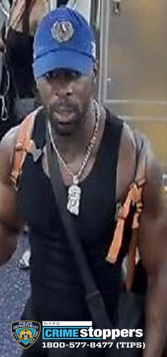 A man wearing a blue baseball cap and a tank top.