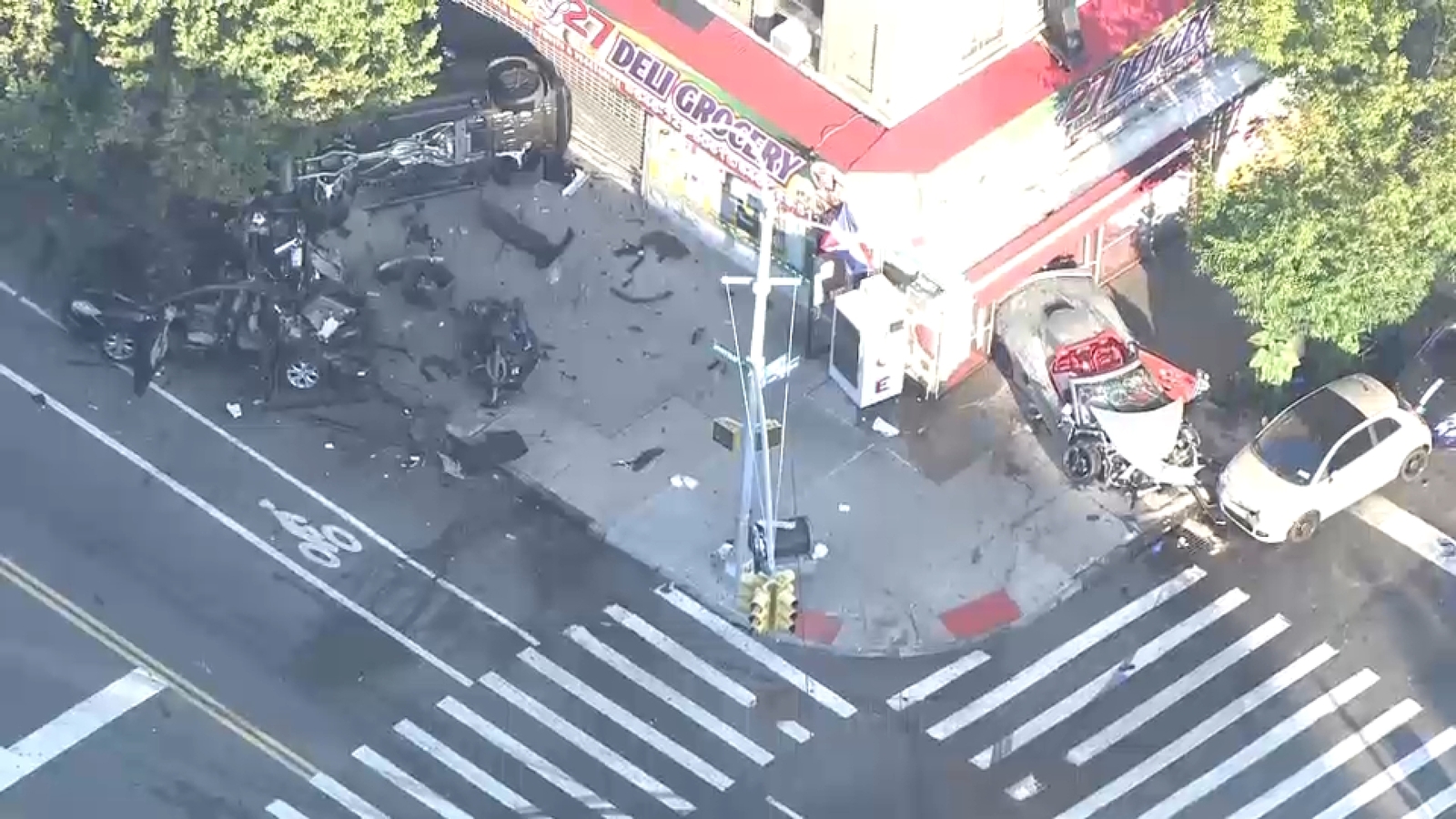 Pedestrian, 2 others hurt when 2 cars crash and jump curb in Inwood, Manhattan; parked vehicles also damaged