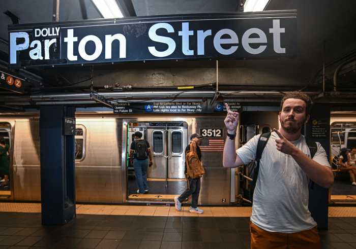 man pointing to a sign in the subway station