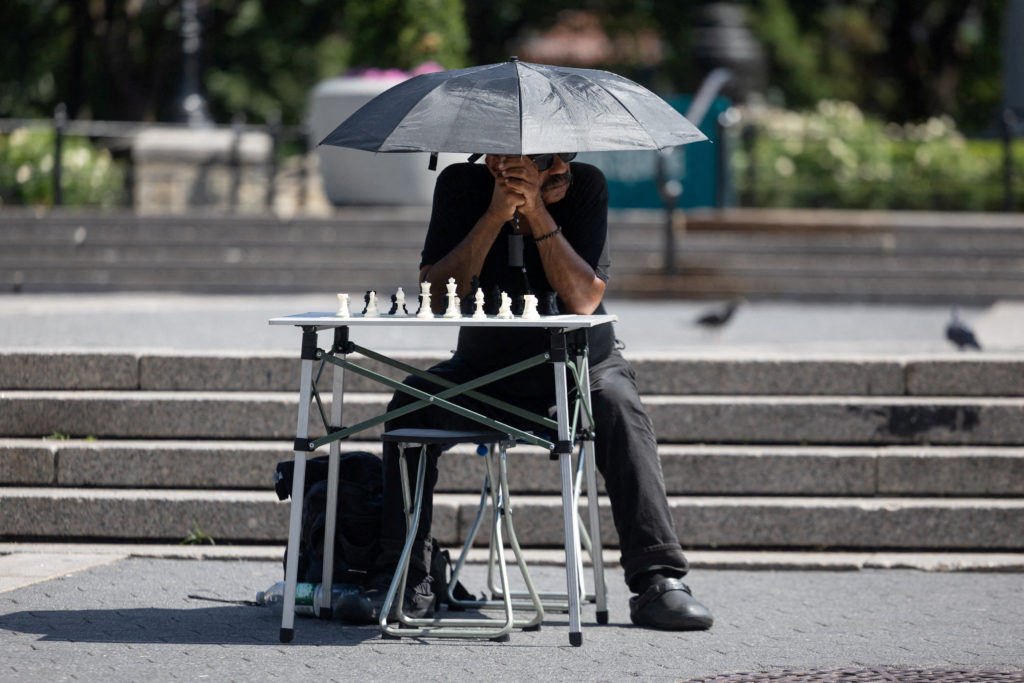 A man waits to play chess during a heatwave in New York City