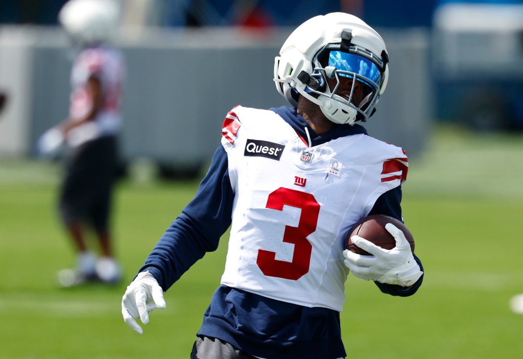 New York Giants wide receiver Odell Beckham Jr. in a white jersey with the number 3, holding a football.